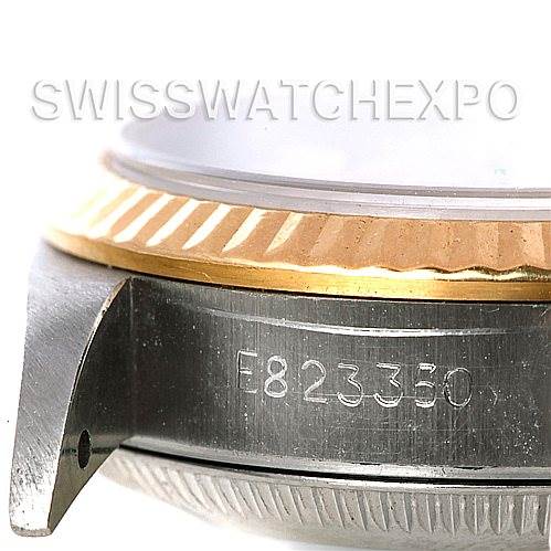 This close-up image of a Rolex Oyster Perpetual 67193 Women
s Steel and Gold (two tone) Silver Dial 67193 Women
s Steel and Gold (two tone) Silver Dial watch shows the bezel, casing, and part of the serial number.