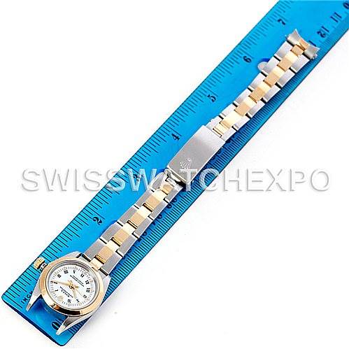 This image shows a top-down view of a Rolex Oyster Perpetual 76183 Women's Steel and Gold (two tone) White Dial 76183 Women's Steel and Gold (two tone) White Dial watch, including its face and bracelet, measured against a ruler.