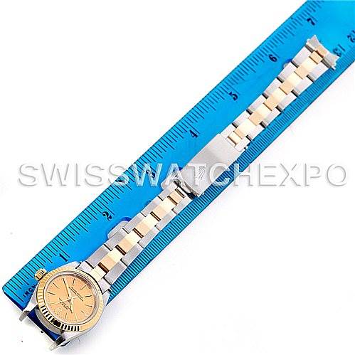 The image shows a Rolex Oyster Perpetual 76193 Women's Steel and Gold (two tone) Champagne Dial 76193 Women's Steel and Gold (two tone) Champagne Dial watch lying flat, displaying the entire band and face alongside a ruler for size reference.