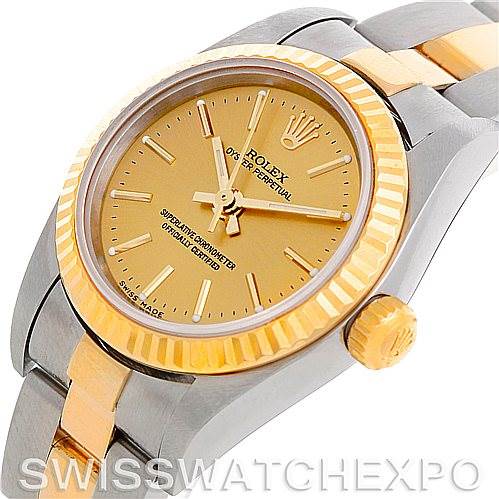The image shows a Rolex Oyster Perpetual 76193 Women's Steel and Gold (two tone) Champagne Dial 76193 Women's Steel and Gold (two tone) Champagne Dial watch at a slight angle, showcasing the dial, bezel, and part of the bracelet.