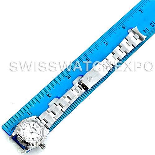 This image shows a Rolex Oyster Perpetual 76094 Women's Stainless Steel White Dial 76094 Women's Stainless Steel White Dial watch laid flat next to a blue ruler for measurement.