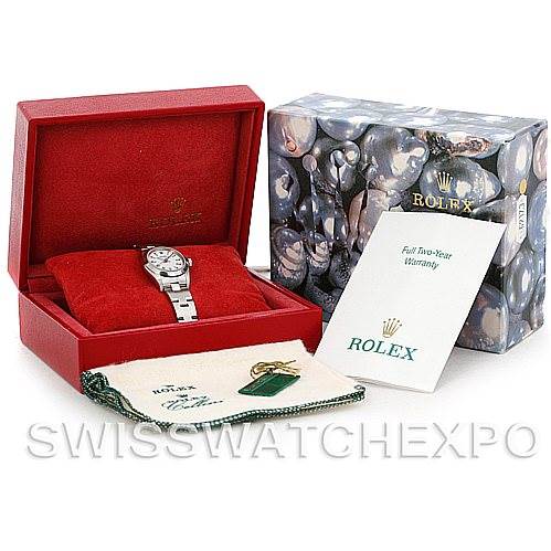 The image shows a Rolex Oyster Perpetual 76080 Women's Stainless Steel White Dial 76080 Women's Stainless Steel White Dial watch and its accessories, including its box, warranty card, and cleaning cloth, at an angled view.