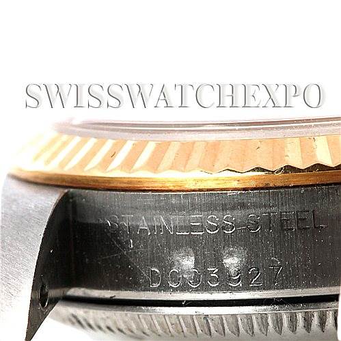 This image shows a close-up of the side of a Rolex Oyster Perpetual 76193 Women's Steel and Gold (two tone) Black Dial 76193 Women's Steel and Gold (two tone) Black Dial watch, highlighting the fluted bezel and part of the watch case with engraved details.