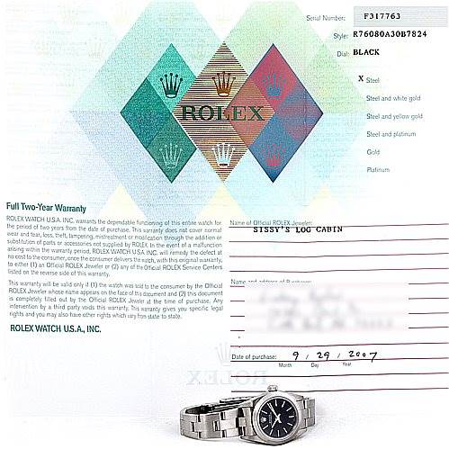 The image shows a Rolex Oyster Perpetual 76080 Women's Stainless Steel Black Dial 76080 Women's Stainless Steel Black Dial watch and its warranty card, highlighting both face and band at a slight side angle.