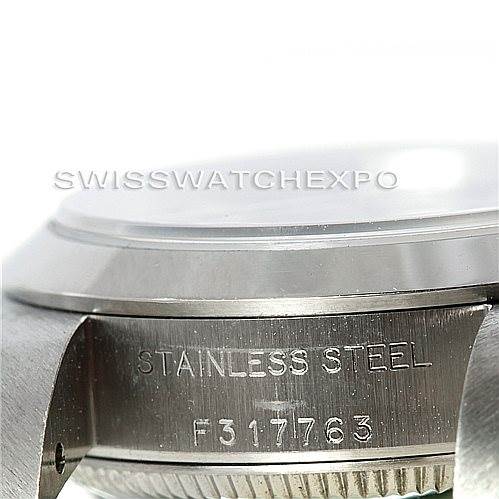 The image shows the side of the Rolex Oyster Perpetual 76080 Women's Stainless Steel Black Dial 76080 Women's Stainless Steel Black Dial watch, focusing on its stainless steel case engraving and serial number.