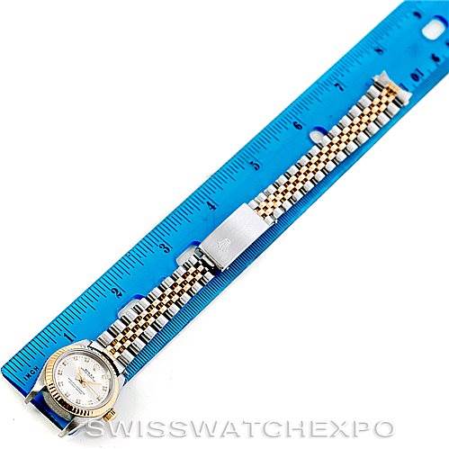 The image shows a top-down view of a Rolex Oyster Perpetual 76193 Women's Steel and Gold (two tone) Silver Dial 76193 Women's Steel and Gold (two tone) Silver Dial watch laid next to a ruler, highlighting the face and bracelet.