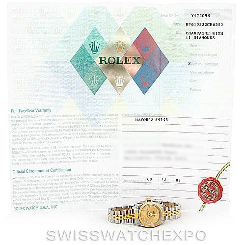 This image shows an Oyster Perpetual Rolex watch positioned in front of its warranty and certification documents.