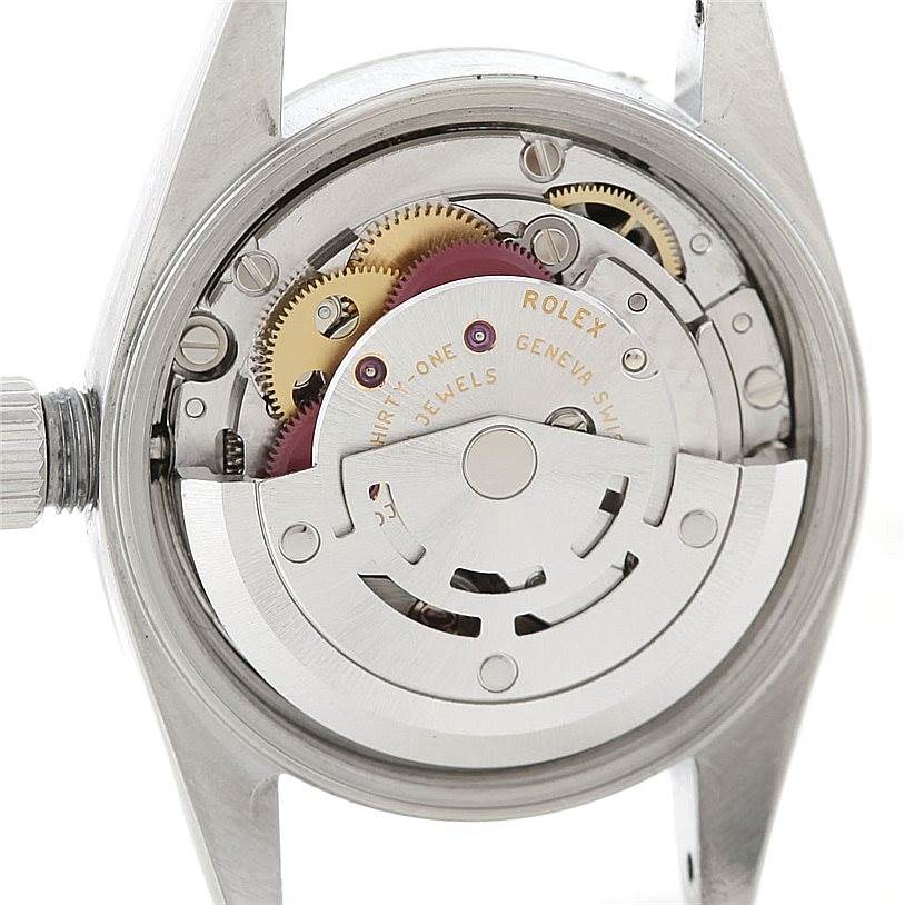 The image shows the internal mechanism of a Rolex Oyster Perpetual 76080 Women's Stainless Steel Black Dial 76080 Women's Stainless Steel Black Dial watch, including gears and the rotor, from a rear angle.