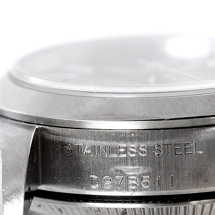 This close-up image shows the side view of the Rolex Oyster Perpetual 76080 Women's Stainless Steel Black Dial 76080 Women's Stainless Steel Black Dial watch case with "Stainless Steel" and serial number engraving.