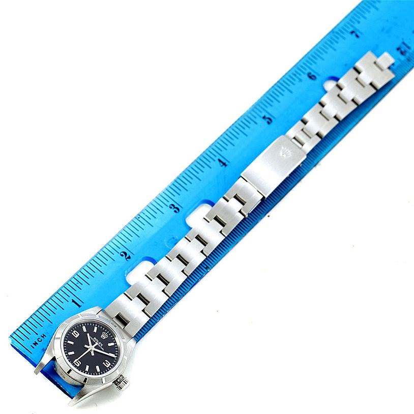 This image shows the front view of a Rolex Oyster Perpetual 76030 Women's Stainless Steel Black Dial 76030 Women's Stainless Steel Black Dial watch alongside a blue ruler.