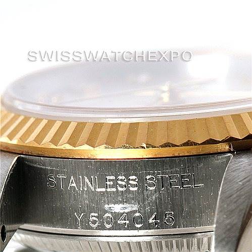 This close-up shows part of the stainless steel case and the fluted bezel of a Rolex Oyster Perpetual 76193 Women's Steel and Gold (two tone) Silver Dial 76193 Women's Steel and Gold (two tone) Silver Dial watch.