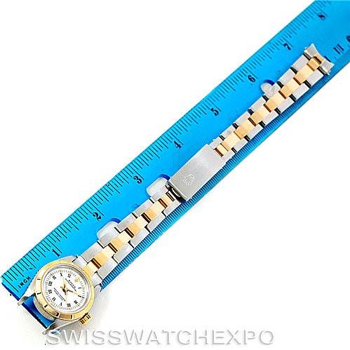 The image shows a full view of a Rolex Oyster Perpetual 67233 Women's Steel and Gold (two tone) White Dial 67233 Women's Steel and Gold (two tone) White Dial watch, laid flat and measured against a blue ruler.