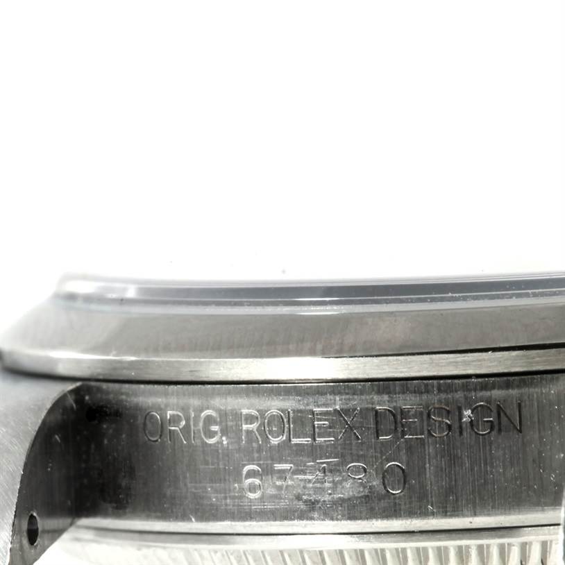 This image shows the side of a Rolex Oyster Perpetual 67180 Women's Stainless Steel Black Dial 67180 Women's Stainless Steel Black Dial watch, highlighting its case and engraved model number.