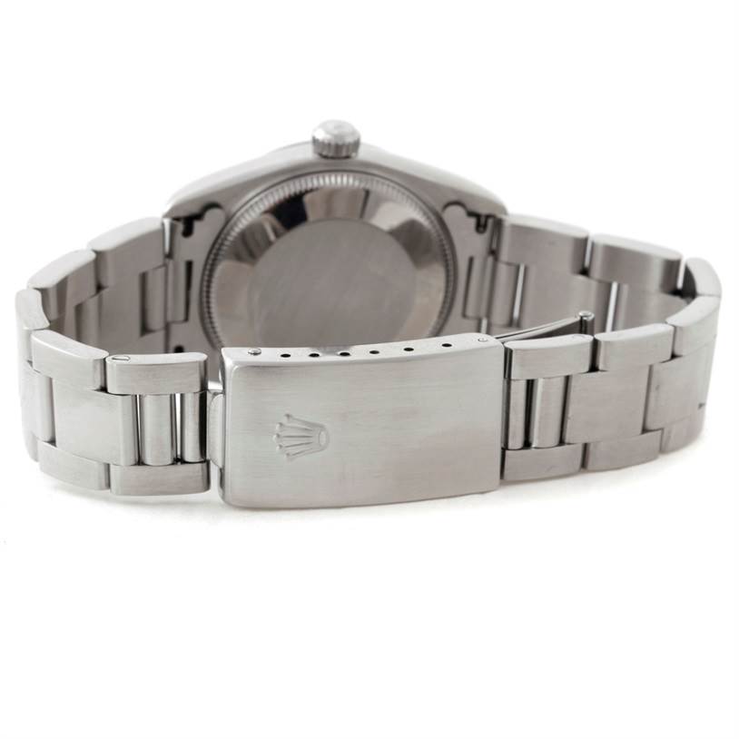 This image shows the backside and clasp of a Rolex Oyster Perpetual 67180 Women's Stainless Steel Black Dial 67180 Women's Stainless Steel Black Dial watch, highlighting the metal bracelet and engraved logo.