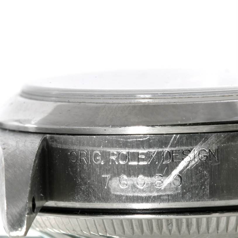 This image shows a close-up side view of the side of the Rolex Oyster Perpetual 76080 Women's Stainless Steel Pink Dial 76080 Women's Stainless Steel Pink Dial watch case with visible engravings.