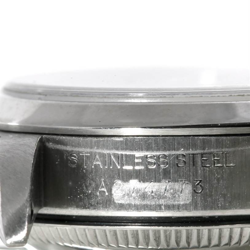 This image shows a close-up side view of a Rolex Oyster Perpetual 76080 Women's Stainless Steel Pink Dial 76080 Women's Stainless Steel Pink Dial watch, highlighting the stainless steel case back with engraved text.