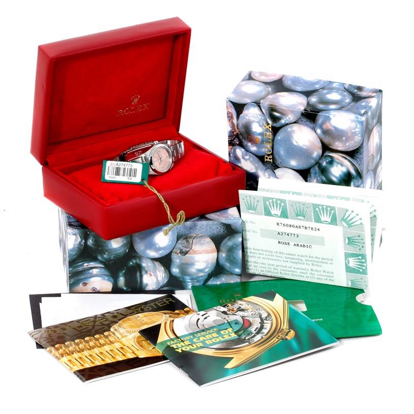The image shows a Rolex Oyster Perpetual 76080 Women's Stainless Steel Pink Dial 76080 Women's Stainless Steel Pink Dial watch in its open box, surrounded by the packaging and documentation.