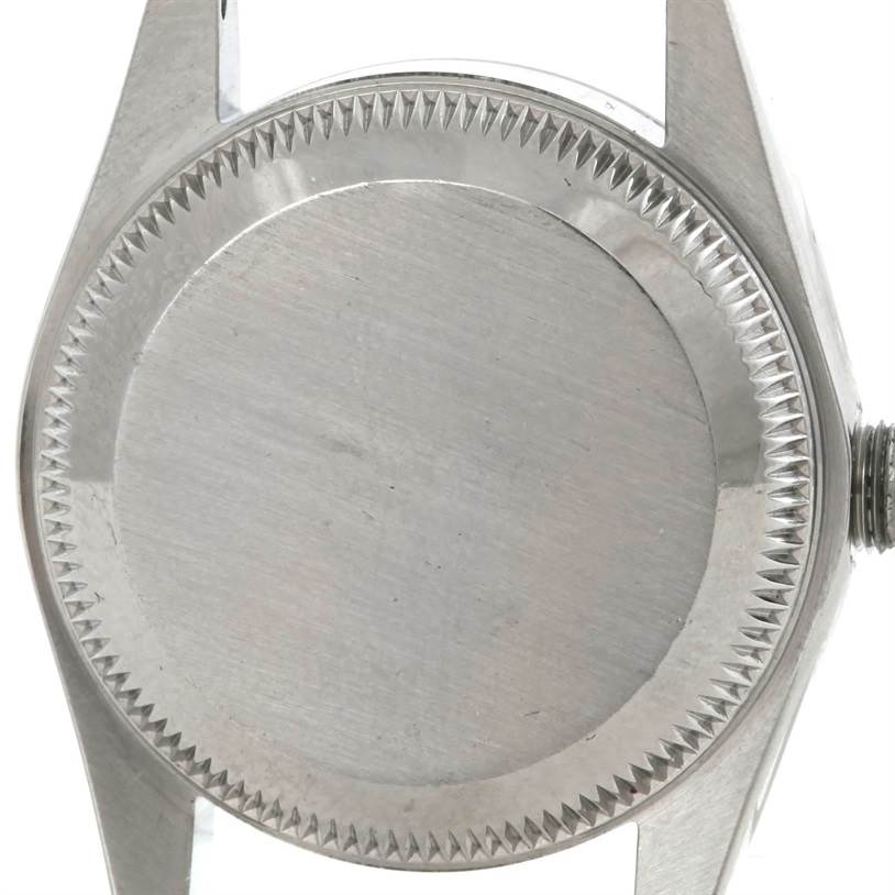 The image shows the case back of a Rolex Oyster Perpetual 67230 Women's Stainless Steel Blue Dial 67230 Women's Stainless Steel Blue Dial watch from a top-down angle.