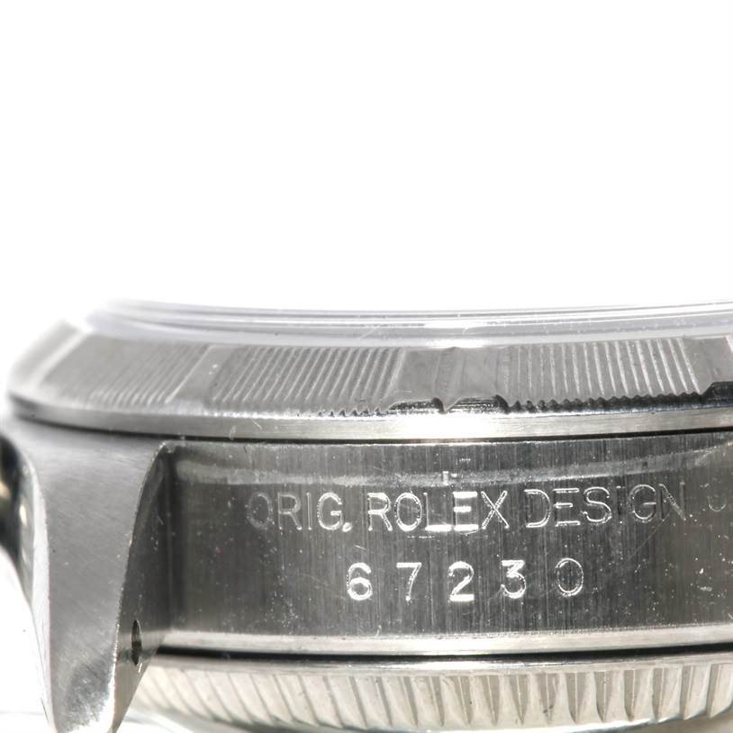 This image shows a close-up side view of the case and bezel of a Rolex Oyster Perpetual 67230 Women's Stainless Steel Blue Dial 67230 Women's Stainless Steel Blue Dial watch, highlighting the serial number engraving.