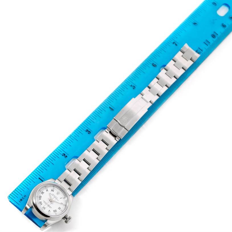 The image shows a Rolex Oyster Perpetual 176200 Women's Stainless Steel White Dial 176200 Women's Stainless Steel White Dial watch with its bracelet laid next to a blue ruler for measurement.