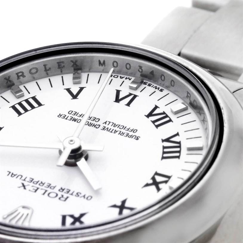 The image shows a close-up of the Rolex Oyster Perpetual 176200 Women's Stainless Steel White Dial 176200 Women's Stainless Steel White Dial's dial, bezel, and part of the bracelet from an angle.
