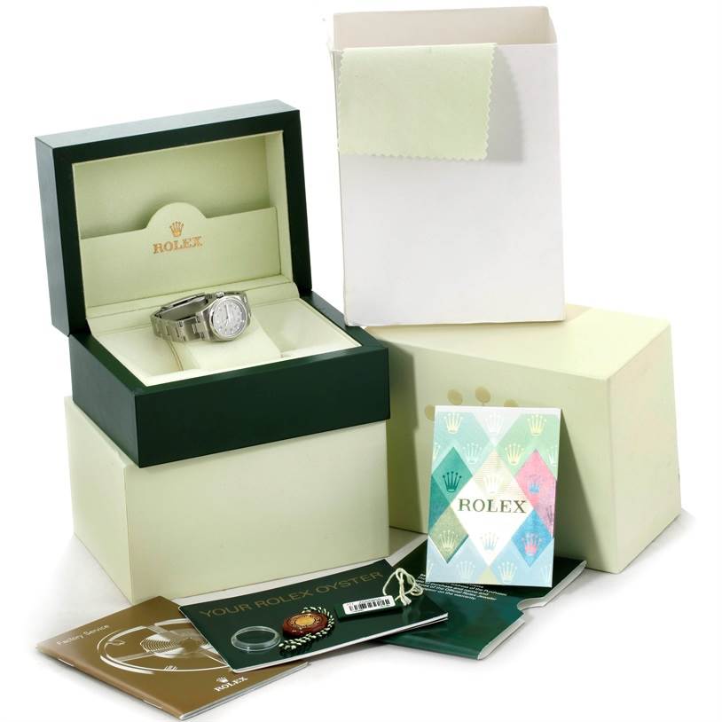 The image shows a Rolex Oyster Perpetual 176200 Women's Stainless Steel Silver Dial 176200 Women's Stainless Steel Silver Dial watch in its box, along with booklets, a cleaning cloth, a warranty card, and tags.