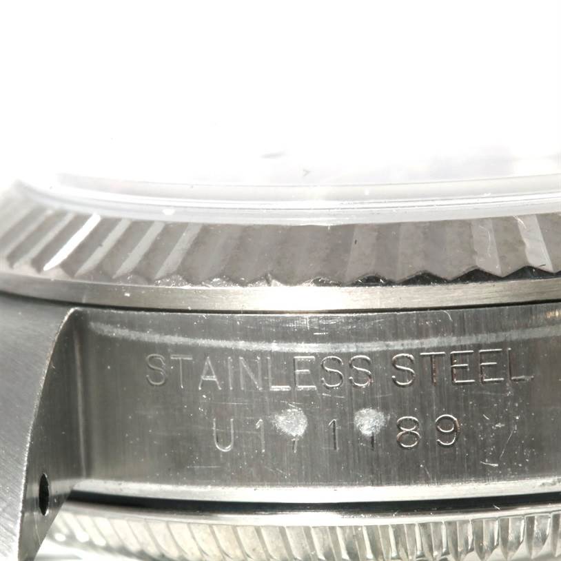 The image shows a close-up of the side of an Oyster Perpetual Rolex watch, highlighting the "STAINLESS STEEL" engraving and part of the bezel.