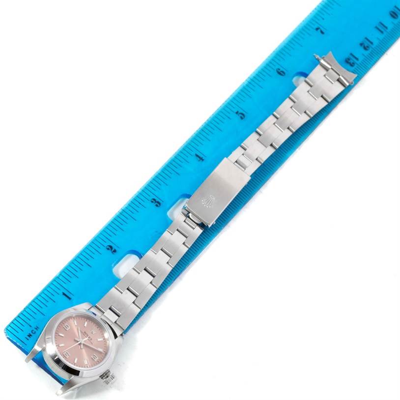 The Rolex Oyster Perpetual 76080 Women's Stainless Steel Pink Dial 76080 Women's Stainless Steel Pink Dial watch is shown from a top-down angle, featuring its full strap and clasp measured against a ruler.