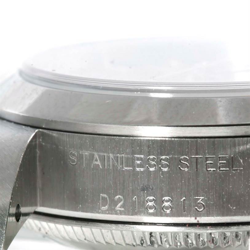 The image shows a close-up of the side of a Rolex Oyster Perpetual 76080 Women's Stainless Steel Pink Dial 76080 Women's Stainless Steel Pink Dial watch case, showcasing its stainless steel material and serial number.