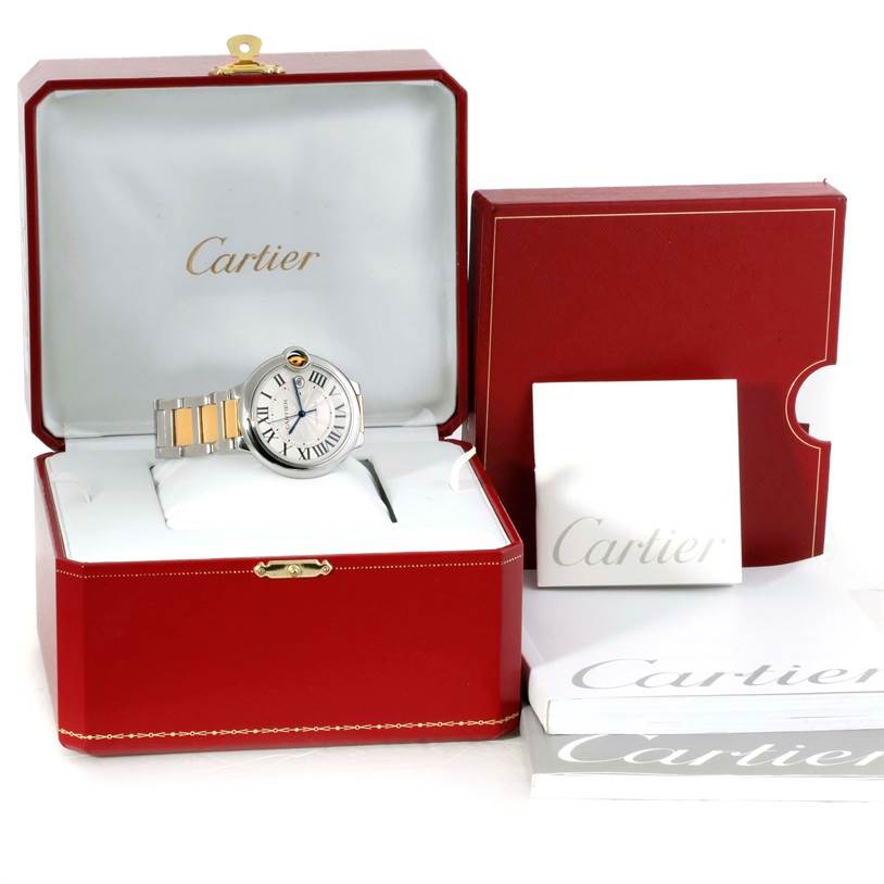 The image shows a Cartier Ballon Bleu W69009Z3 Men's Stainless Steel Silver Dial W69009Z3 Men's Stainless Steel Silver Dial watch in its opened red packaging box, along with documentation and an additional box.