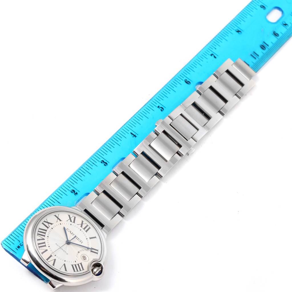 The image shows a top-down view of a Cartier Ballon Bleu W69012Z4 Men's Stainless Steel Silver Dial W69012Z4 Men's Stainless Steel Silver Dial watch, highlighting its face and metal bracelet alongside a ruler.