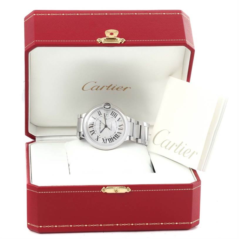 The Ballon Bleu de Cartier watch is displayed front-on inside an open Cartier box with a booklet beside it.