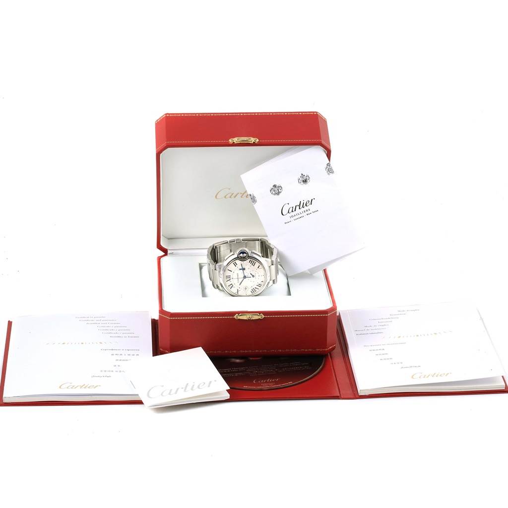 The image shows a Cartier Ballon Bleu W6920002 Stainless Steel Silver Dial W6920002 Stainless Steel Silver Dial watch displayed in an open red box, accompanied by booklets and documents.