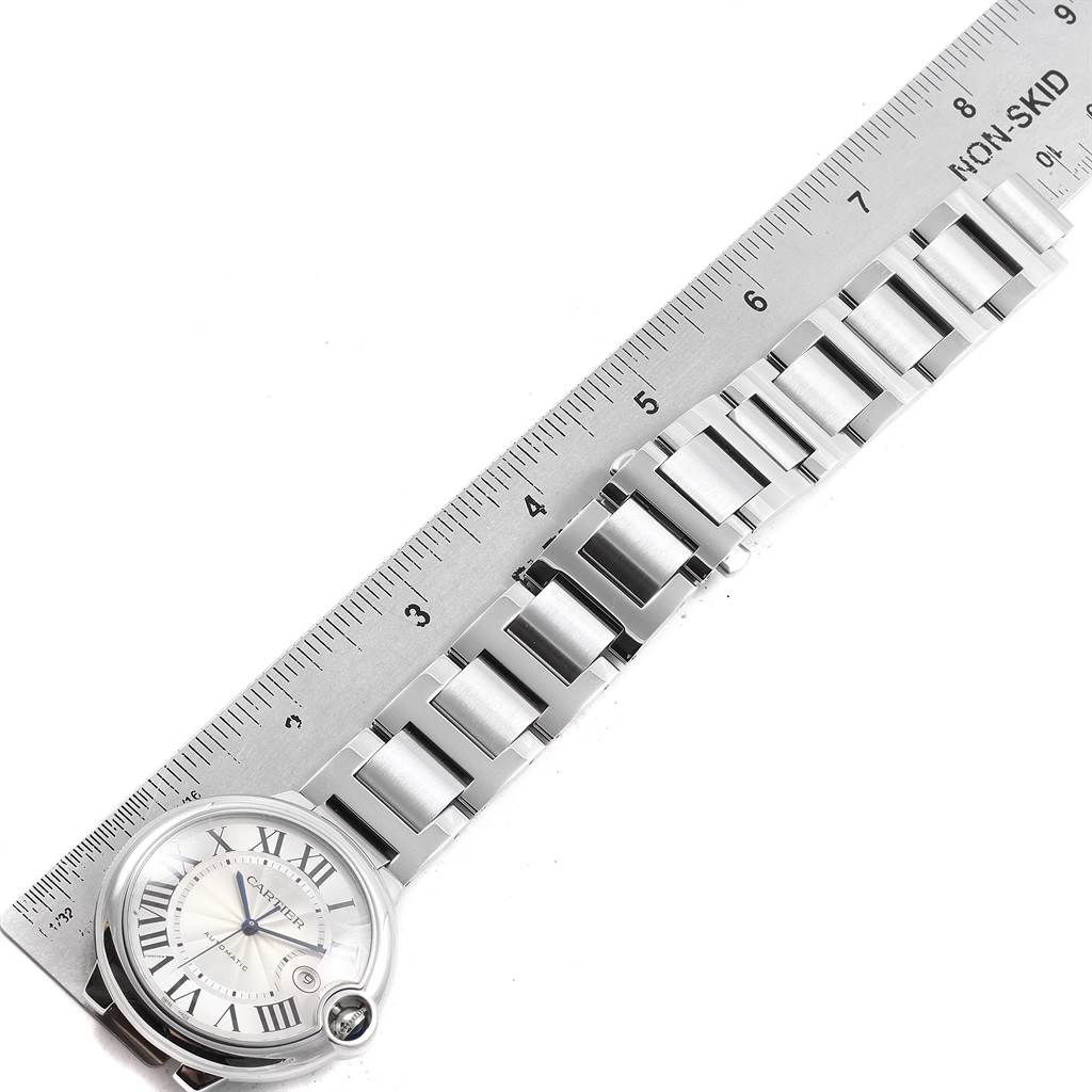 The image shows a flat lay angle of a Cartier Ballon Bleu W69012Z4 Men's Stainless Steel Silver Dial W69012Z4 Men's Stainless Steel Silver Dial watch with its strap and a ruler for scale.