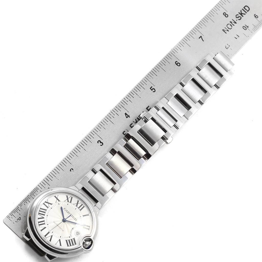 This image shows a Cartier Ballon Bleu W69012Z4 Men
s Stainless Steel Silver Dial W69012Z4 Men
s Stainless Steel Silver Dial watch placed next to a ruler, displaying its face and metal bracelet.