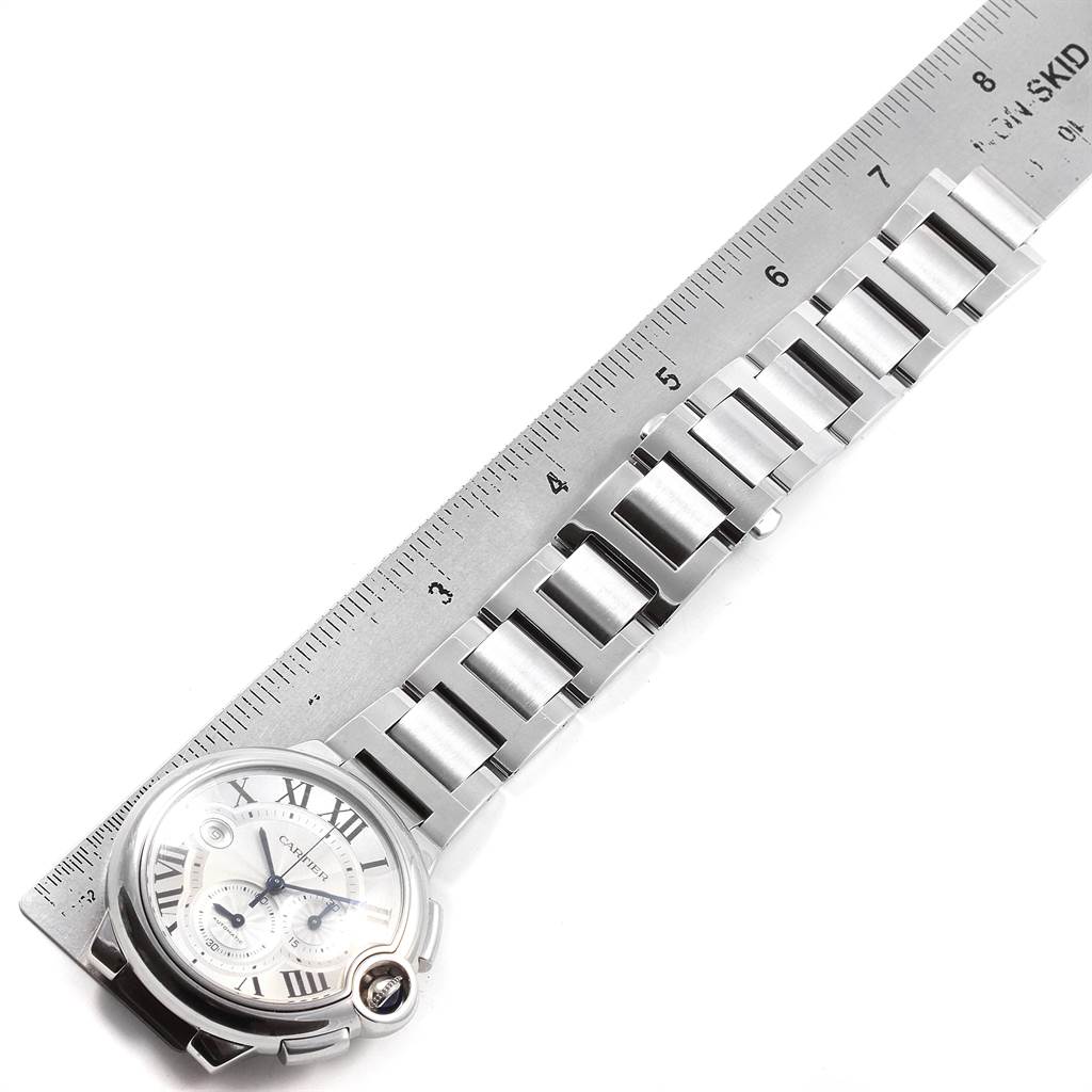 This image shows a Cartier Ballon Bleu W6920002 Men
s Stainless Steel Silver Dial W6920002 Men
s Stainless Steel Silver Dial watch laying flat, alongside a ruler, highlighting the watch face and bracelet.