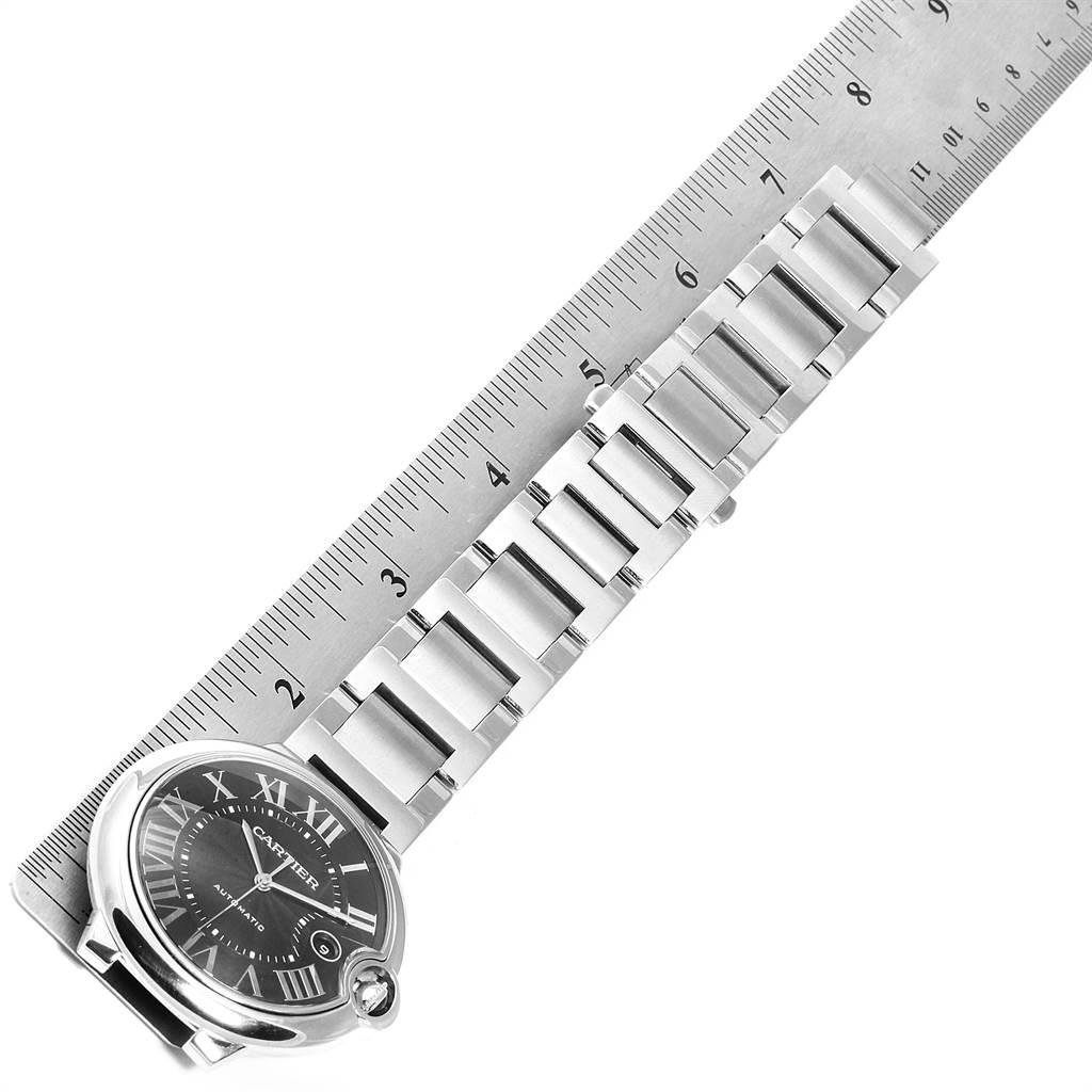 The image shows a top view of a Ballon Bleu watch by Cartier, featuring its face, case, and bracelet measured against a ruler.