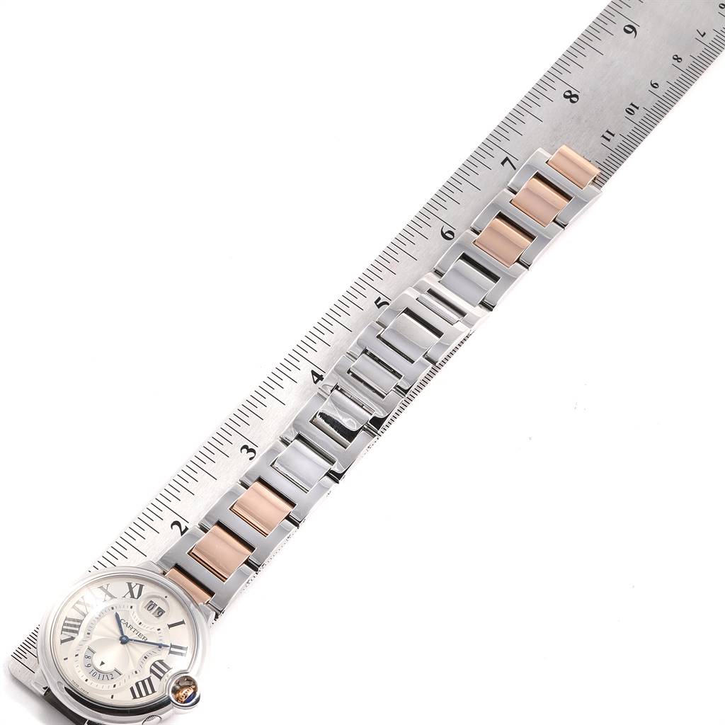 The image shows the Cartier Ballon Bleu W6920027 Men's Steel and Gold (two tone) Silver Dial W6920027 Men's Steel and Gold (two tone) Silver Dial watch, featuring the face and part of the metal bracelet, alongside a ruler for scale.