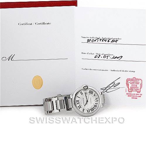 This image shows a Cartier Ballon Bleu W69012Z4 Men
s Stainless Steel Silver Dial W69012Z4 Men
s Stainless Steel Silver Dial watch resting on its side with its certificate papers displayed behind it.