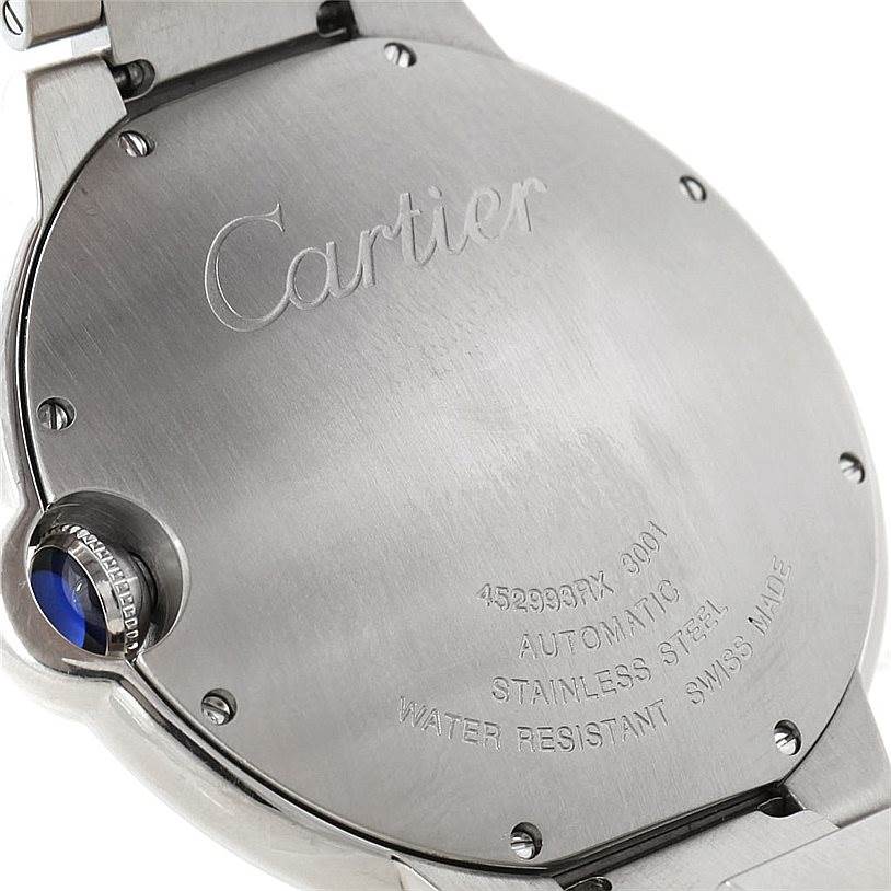 The image shows the back of a Ballon Bleu watch by Cartier, highlighting the engravings and crown with a blue cabochon.