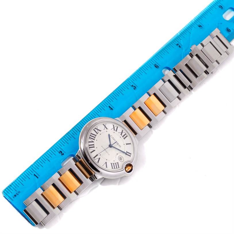 The image shows a Cartier Ballon Bleu W69009Z3 Men
s Stainless Steel Silver Dial W69009Z3 Men
s Stainless Steel Silver Dial watch placed flat next to a blue ruler, highlighting its dial and bracelet.