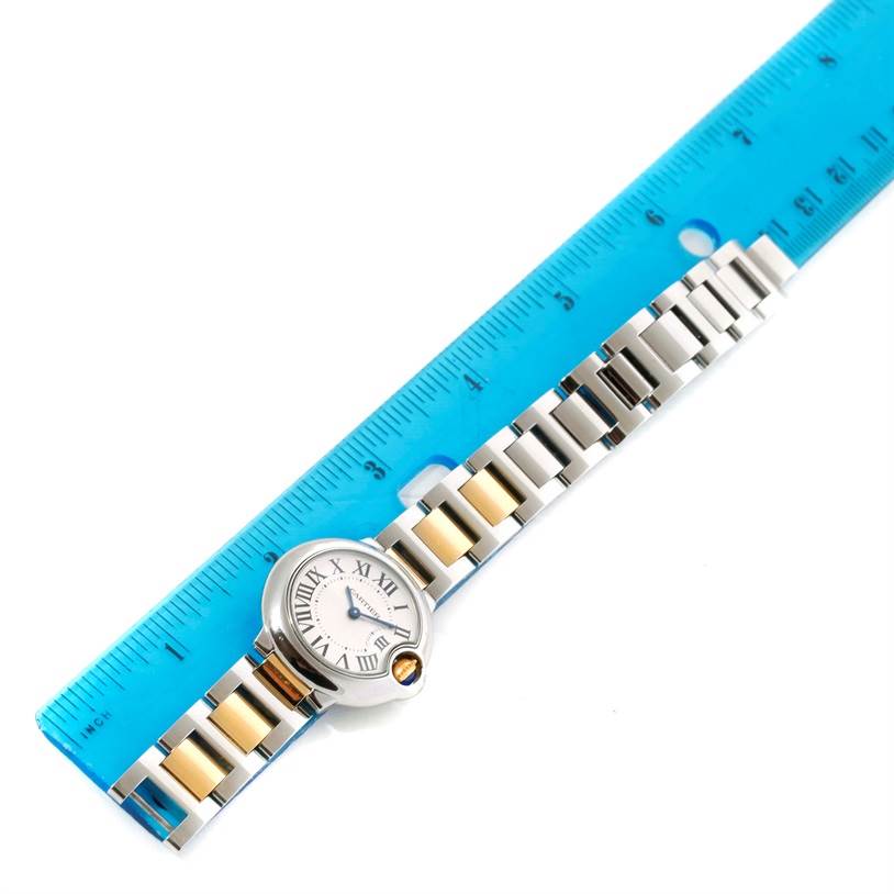 The image shows a top-down view of a Ballon Bleu watch by Cartier, placed next to a ruler for scale.