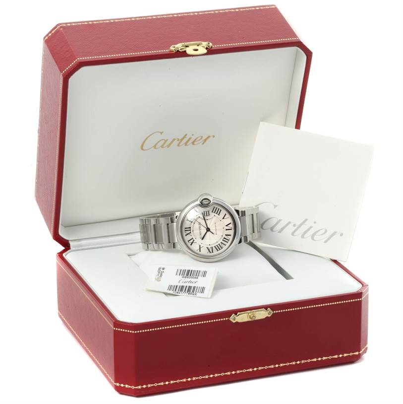 The Cartier Ballon Bleu W6920046 Women
s Stainless Steel Silver Dial W6920046 Women
s Stainless Steel Silver Dial watch is shown head-on inside its open red box, displaying its bracelet and face.