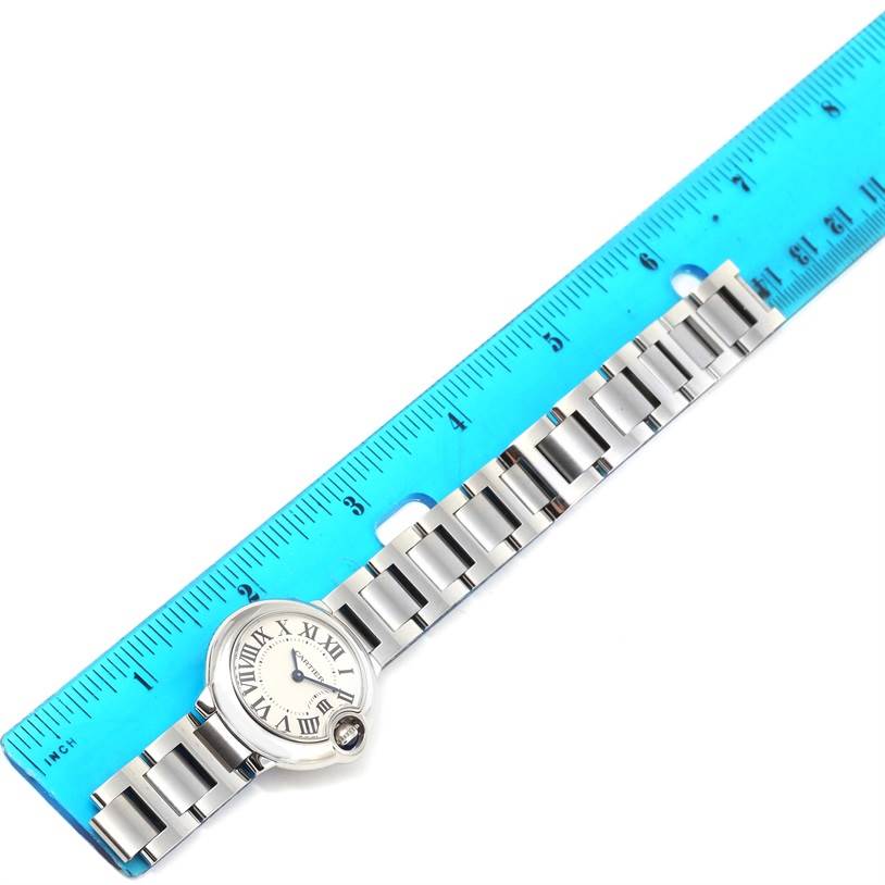 This image shows a Cartier Ballon Bleu W69010Z4 Women
s Stainless Steel Silver Dial W69010Z4 Women
s Stainless Steel Silver Dial watch laid flat next to a blue ruler, highlighting the face and bracelet.