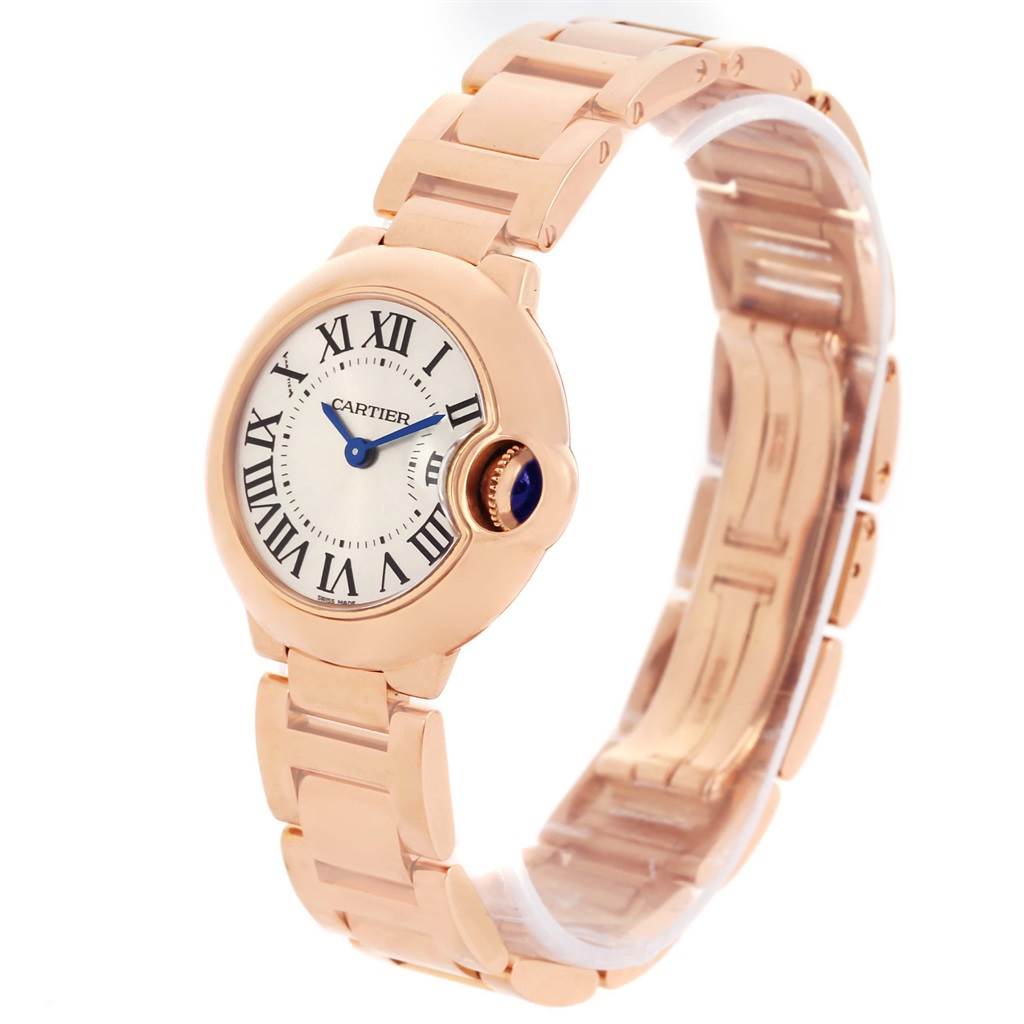 The image shows a Ballon Bleu model by Cartier at an angle highlighting its face, blue hands, Roman numerals, and rose gold bracelet.