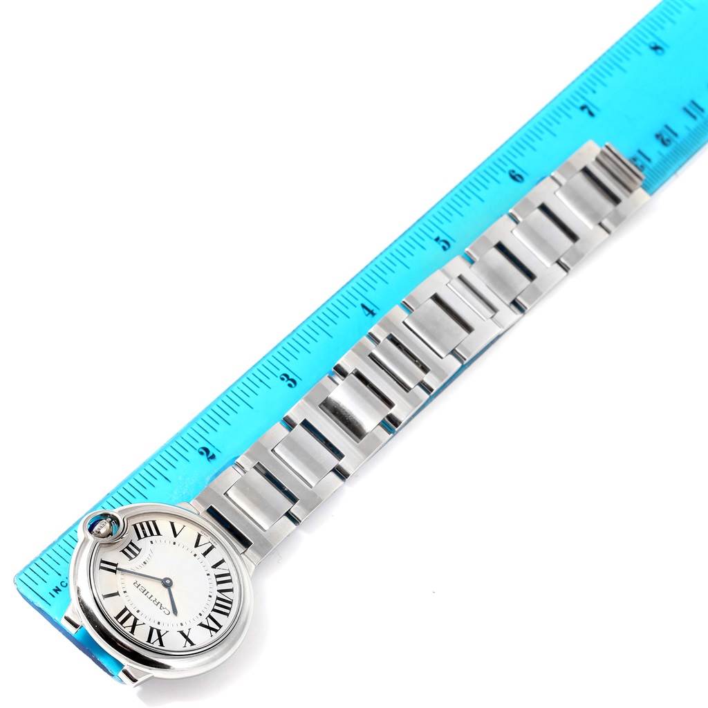 The image shows a Cartier Ballon Bleu W69011Z4 Women
s Stainless Steel Silver Dial W69011Z4 Women
s Stainless Steel Silver Dial watch face and bracelet, positioned alongside a blue ruler for measurement.