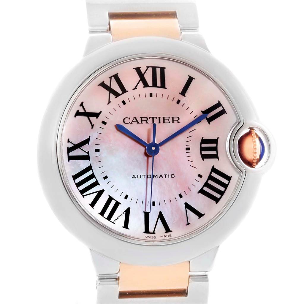 The image shows a front view of a Ballon Bleu model by Cartier, featuring Roman numerals, blue hands, and a fluted crown with a blue cabochon.