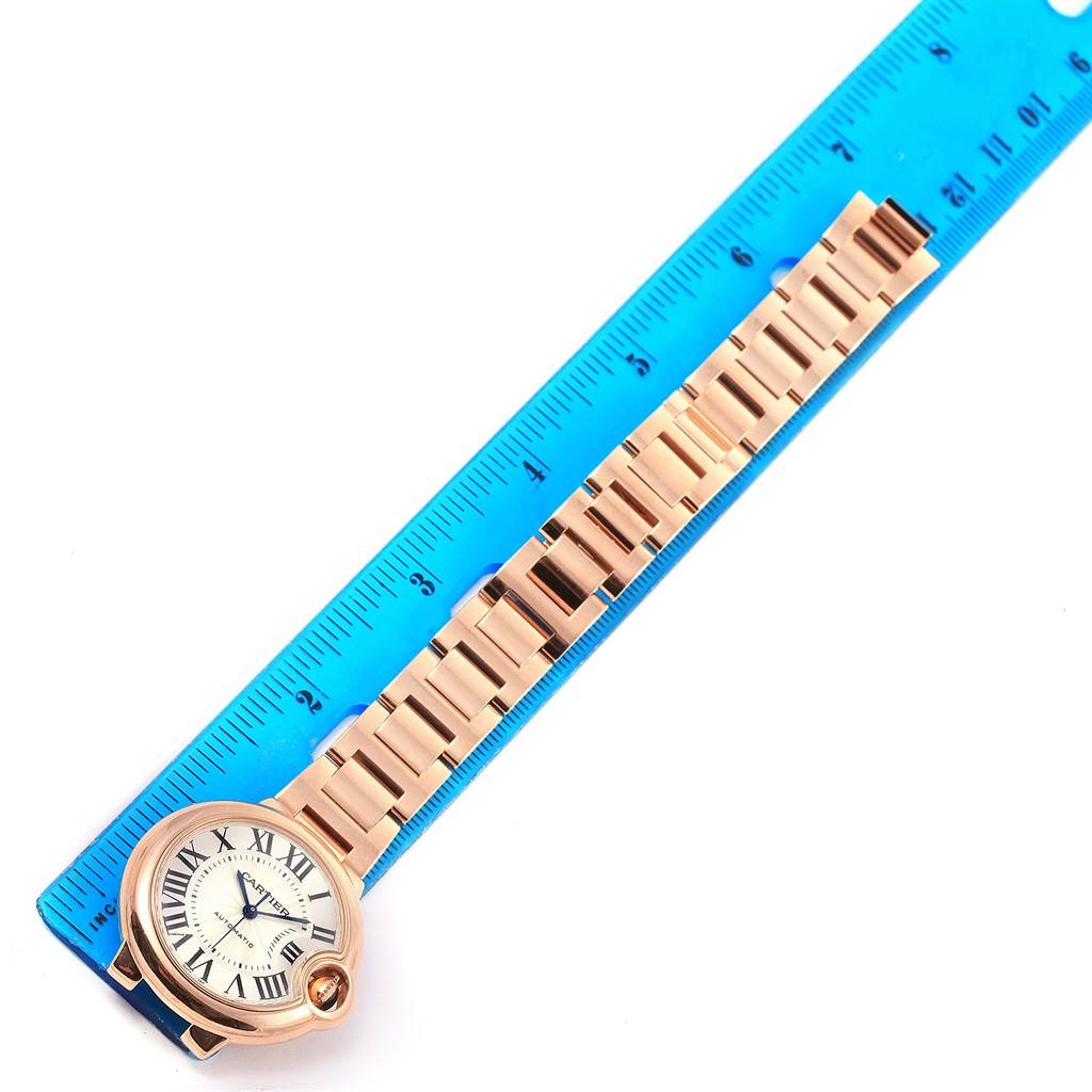 The image shows a top-down view of a Ballon Bleu de Cartier watch, aligned with a ruler for measurement.