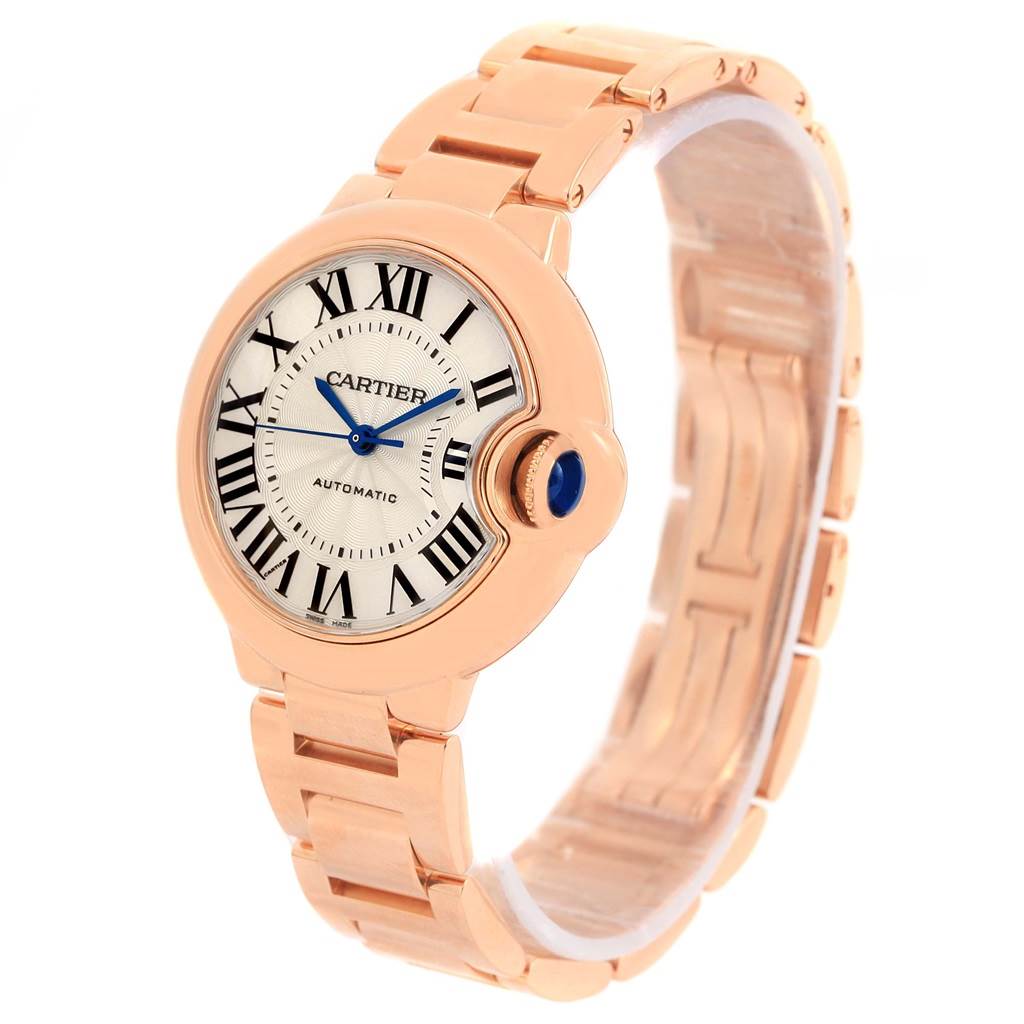 This image shows a Cartier Ballon Bleu W6920096 Women's Rose Gold Silver Dial W6920096 Women's Rose Gold Silver Dial watch at an angle highlighting its face, crown, and part of the bracelet.