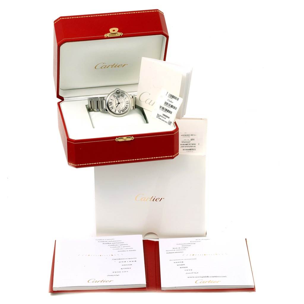 The image shows a Ballon Bleu by Cartier watch in its red box, along with warranty booklets and documentation.